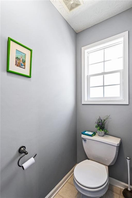 bathroom featuring toilet, baseboards, visible vents, and tile patterned floors