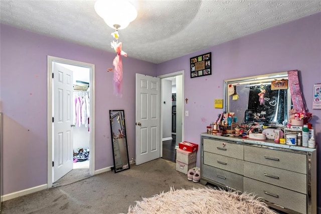 bedroom featuring baseboards, a textured ceiling, and light colored carpet