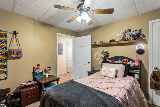 bedroom featuring a paneled ceiling, ceiling fan, electric panel, and tile patterned floors