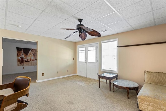 living area featuring carpet, baseboards, visible vents, and a drop ceiling