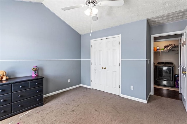 carpeted bedroom featuring lofted ceiling, baseboards, washer / clothes dryer, and a textured ceiling