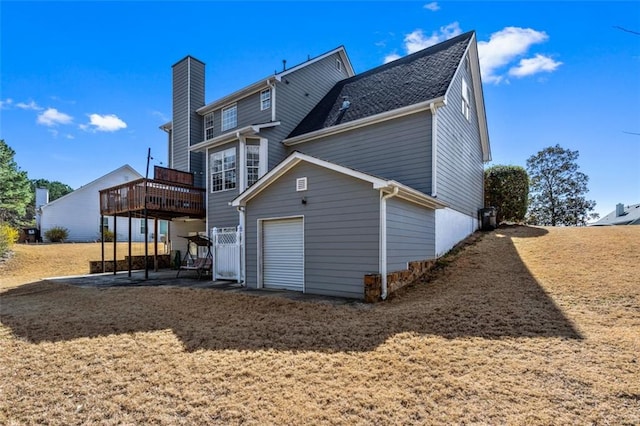 rear view of house featuring a deck, a patio, and a garage