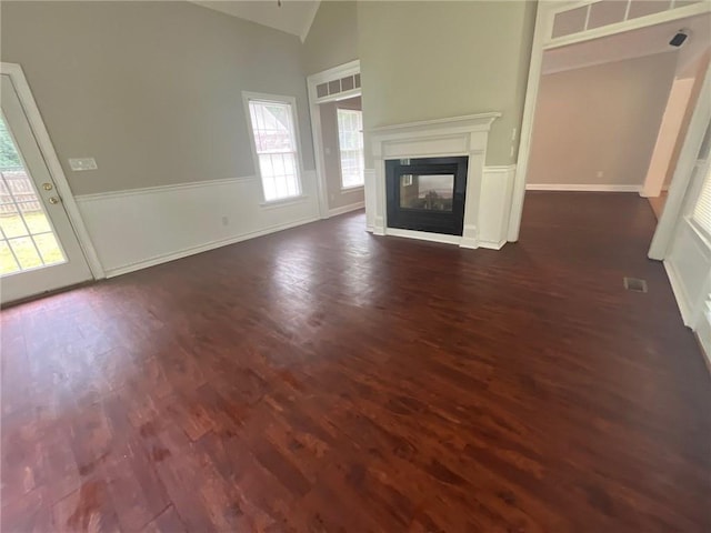 100 Hamilton Glen Ct, Fayetteville, GA 30215 - unfurnished living room featuring lofted ceiling, dark wood-style flooring, and a multi sided fireplace