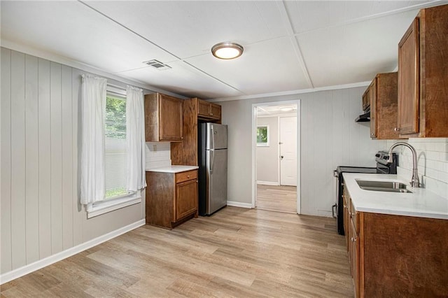 1186 Eastview Rd NE, Conyers, GA 30012 - kitchen featuring freestanding refrigerator, electric range, brown cabinets, light wood finished floors, and ornamental molding