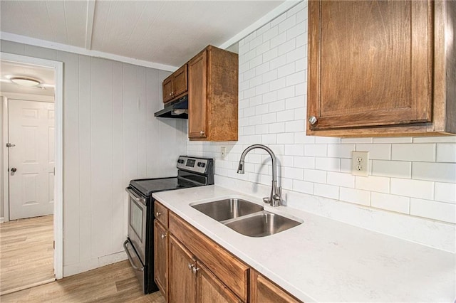 1186 Eastview Rd NE, Conyers, GA 30012 - kitchen featuring stainless steel range with electric cooktop, under cabinet range hood, light wood-style floors, brown cabinetry, and light countertops