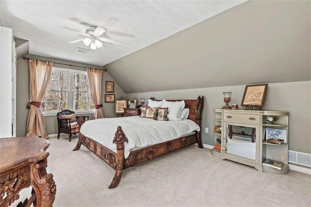 bedroom featuring lofted ceiling, light carpet, visible vents, baseboards, and a ceiling fan