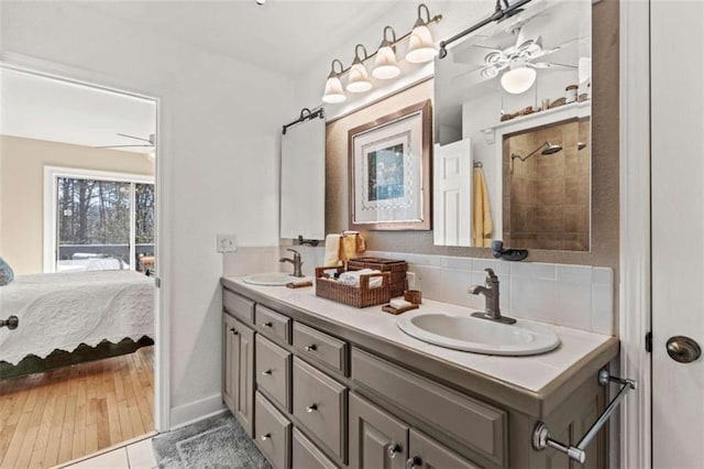 full bath with double vanity, a sink, ensuite bathroom, and ceiling fan