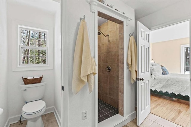 ensuite bathroom featuring a stall shower, tile patterned flooring, toilet, and ensuite bathroom