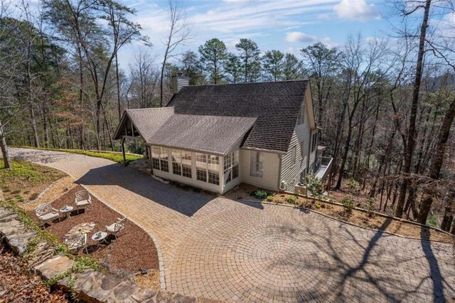 exterior space with entry steps, a chimney, and roof with shingles