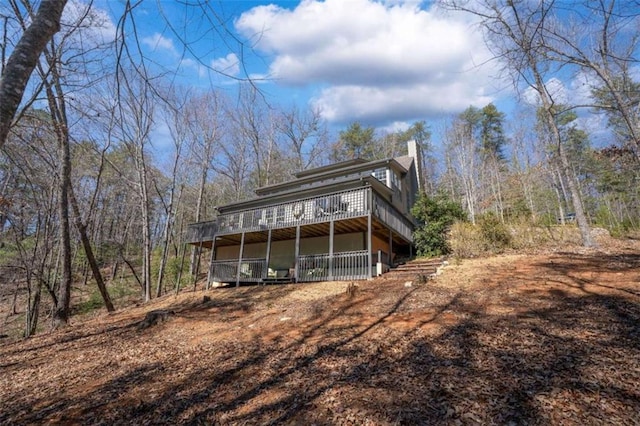 rear view of property with a chimney and a wooden deck