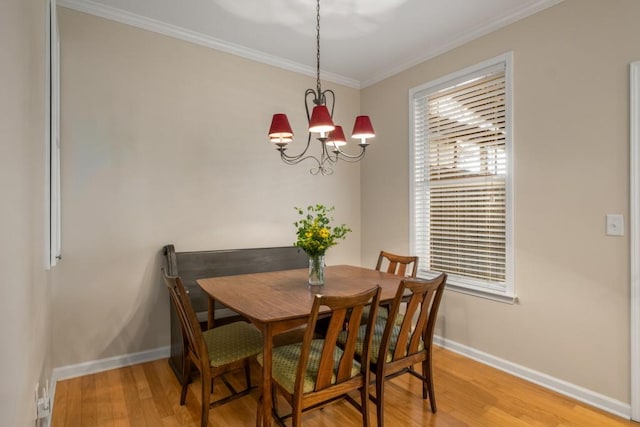 dining room with baseboards, light wood-style floors, a chandelier, and crown molding