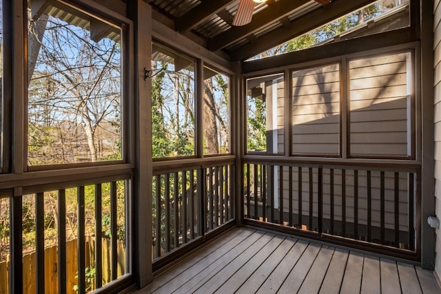 unfurnished sunroom with vaulted ceiling, ceiling fan, and plenty of natural light