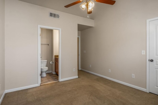 unfurnished bedroom with carpet flooring, a ceiling fan, visible vents, baseboards, and ensuite bath