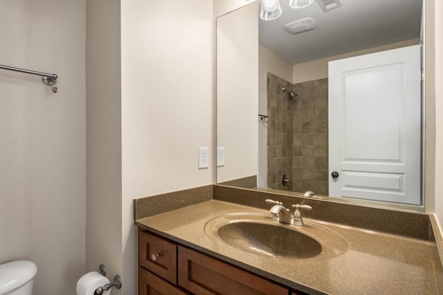 bathroom with toilet, walk in shower, and vanity