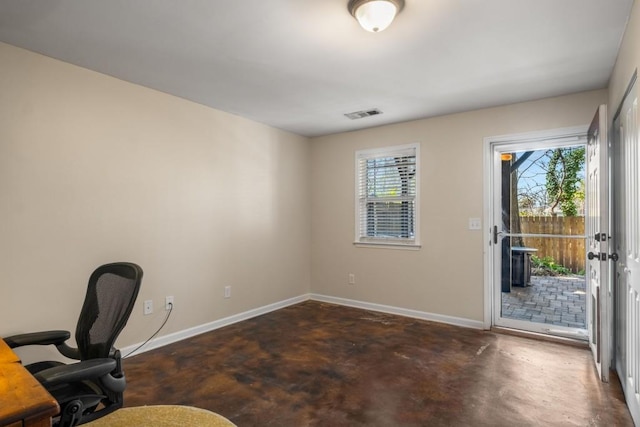 office area featuring a healthy amount of sunlight, baseboards, finished concrete floors, and visible vents