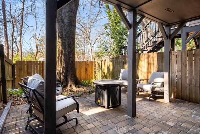 view of patio / terrace featuring a fenced backyard and stairs