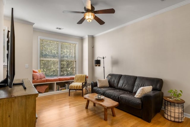 living area with crown molding, ceiling fan, visible vents, and light wood-style floors