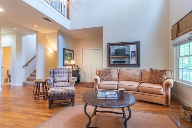 living room featuring a high ceiling and light hardwood / wood-style floors