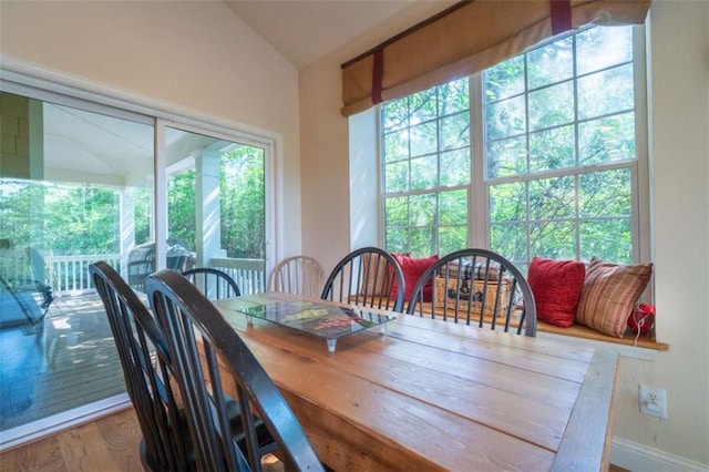 dining area featuring lofted ceiling and hardwood / wood-style flooring