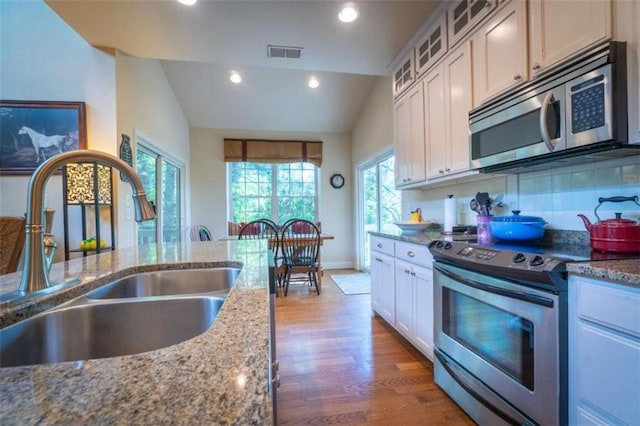 kitchen featuring lofted ceiling, sink, white cabinetry, and stainless steel appliances