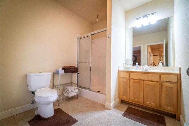 bathroom with tile patterned flooring, vanity, toilet, and walk in shower