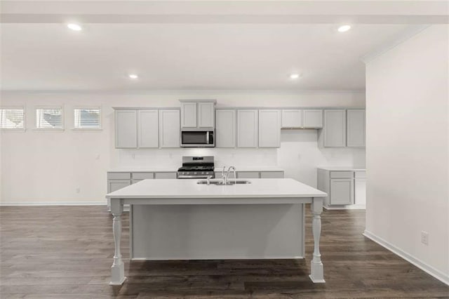 kitchen featuring light countertops, appliances with stainless steel finishes, an island with sink, and a sink