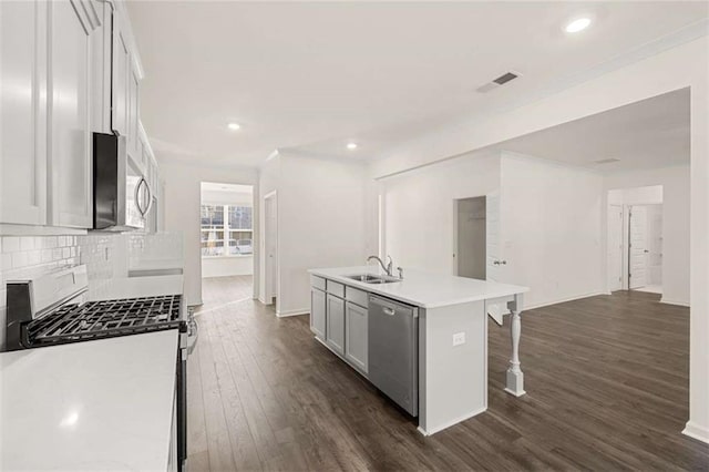 kitchen featuring visible vents, dark wood-type flooring, a kitchen island with sink, stainless steel appliances, and light countertops