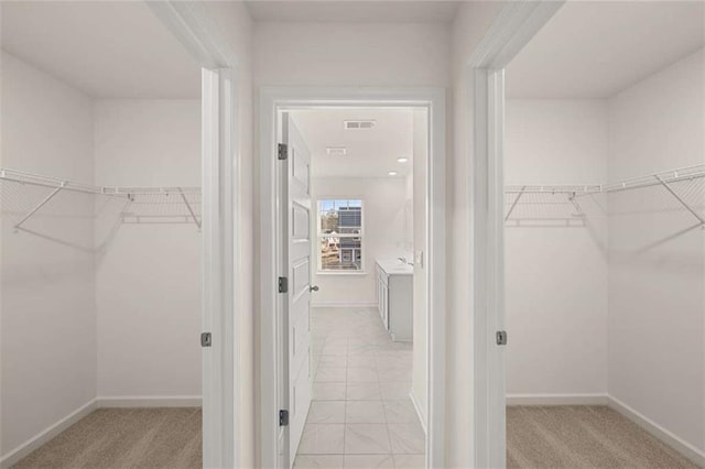 spacious closet with light colored carpet and visible vents