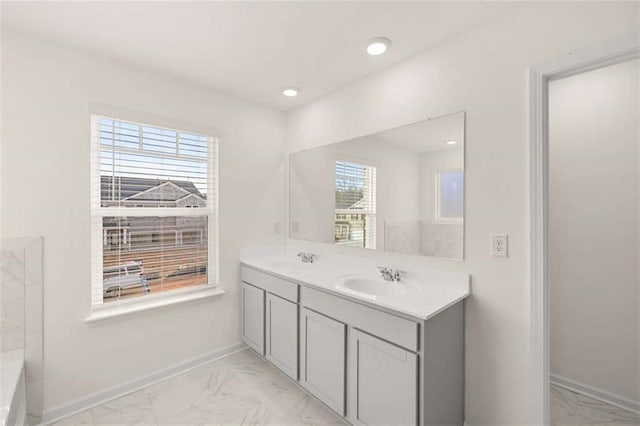 full bath with marble finish floor, baseboards, and a sink