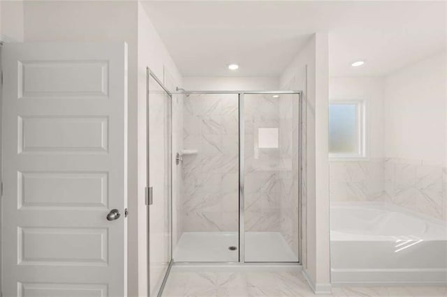 bathroom with marble finish floor, a marble finish shower, a garden tub, and recessed lighting