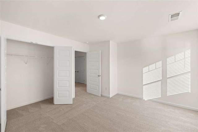 unfurnished bedroom with light colored carpet, a closet, visible vents, and baseboards