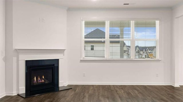 unfurnished living room featuring baseboards, dark wood finished floors, and a glass covered fireplace