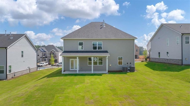 back of property with a residential view, central AC, a yard, and a patio