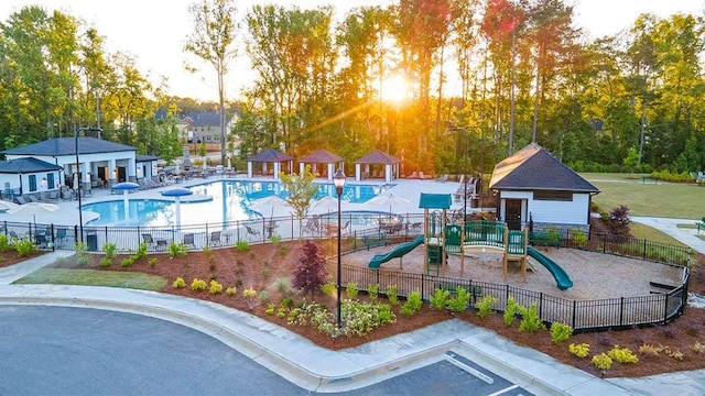 community jungle gym with fence and a community pool