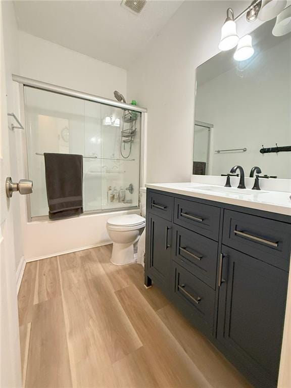 260 Ruby Forest Pkwy, Suwanee, GA 30024 - bathroom featuring wood finished floors, toilet, enclosed tub / shower combo, and vanity