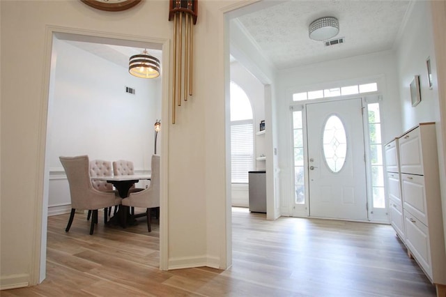 260 Ruby Forest Pkwy, Suwanee, GA 30024 - entrance foyer with crown molding, light wood-style floors, baseboards, and a textured ceiling