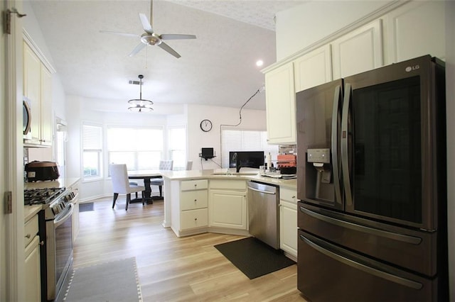 260 Ruby Forest Pkwy, Suwanee, GA 30024 - kitchen featuring stainless steel appliances, a peninsula, vaulted ceiling, ceiling fan, and light wood finished floors
