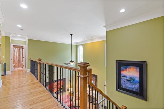 hallway featuring recessed lighting, an upstairs landing, ornamental molding, and wood finished floors
