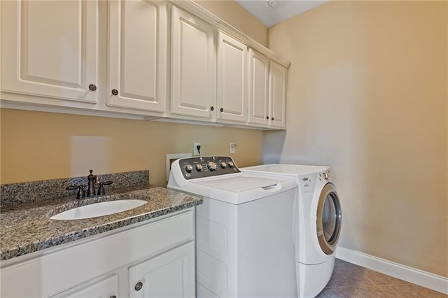 laundry room with tile patterned flooring, cabinet space, a sink, baseboards, and washer and dryer