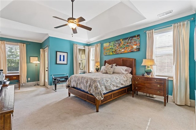bedroom featuring light colored carpet, baseboards, and a tray ceiling