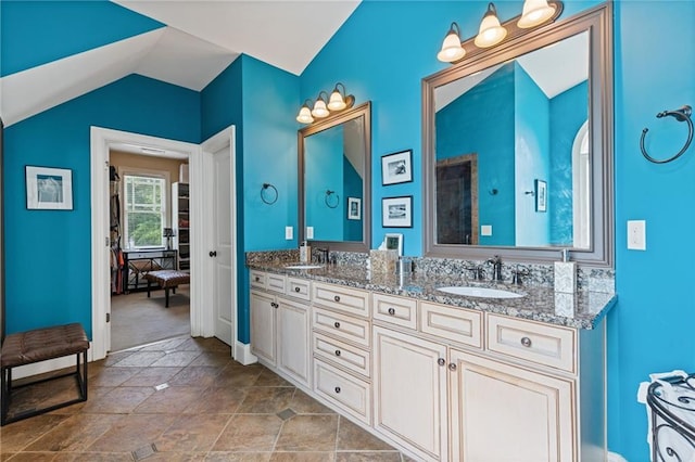 bathroom featuring double vanity, a sink, and lofted ceiling
