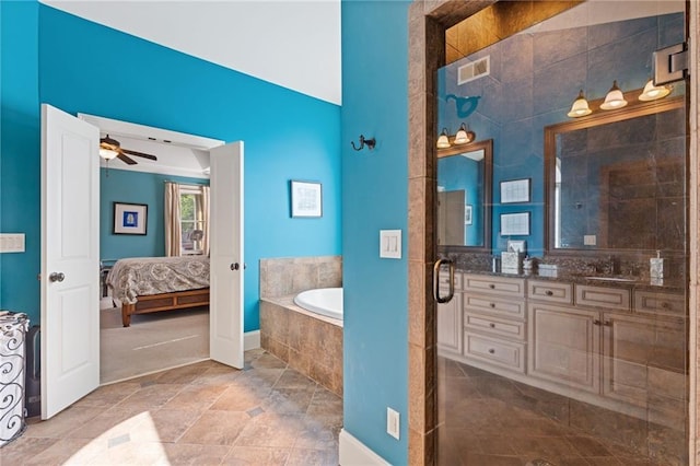bathroom with visible vents, vanity, ceiling fan, a bath, and ensuite bath