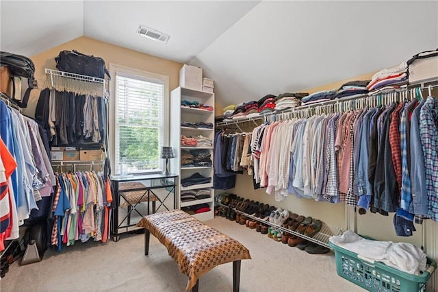 walk in closet featuring carpet, lofted ceiling, and visible vents