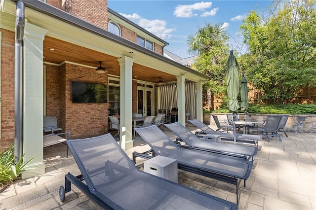 view of patio with fence, a ceiling fan, and outdoor dining area