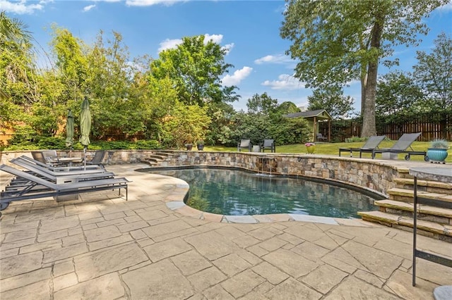 view of swimming pool featuring fence, a fenced in pool, a lawn, and a patio area