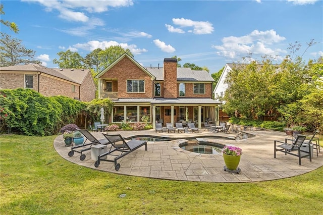 back of property featuring an in ground hot tub, a chimney, an outdoor pool, a patio area, and a yard