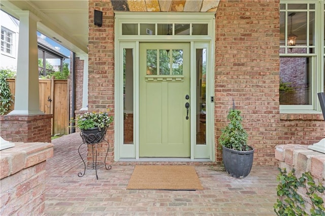 property entrance with brick siding and covered porch