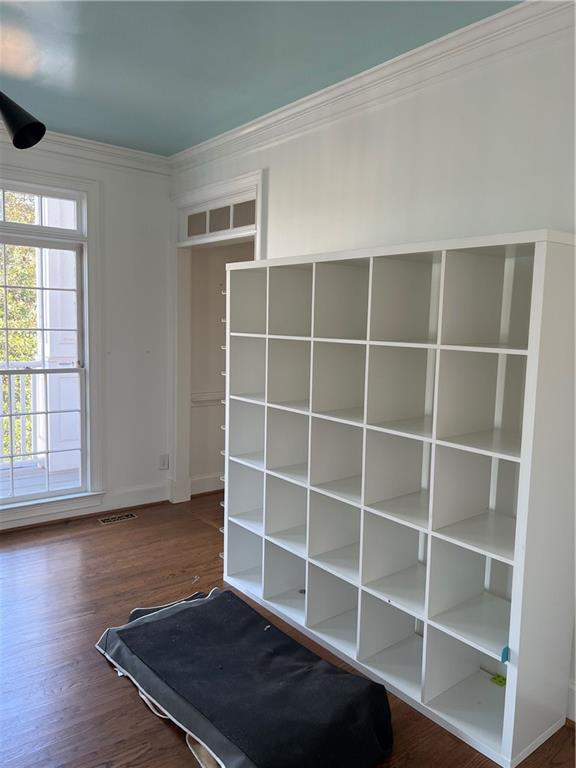 interior space featuring crown molding and dark hardwood / wood-style flooring