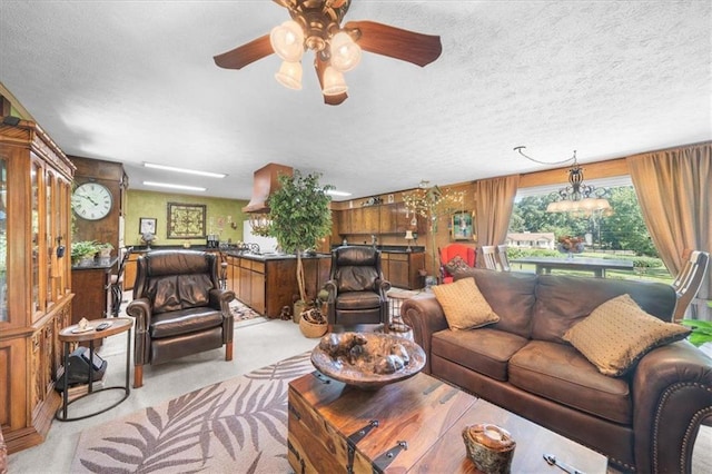 living room featuring light carpet, a textured ceiling, wooden walls, and ceiling fan