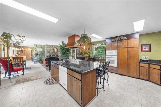 kitchen featuring white appliances, a center island, pendant lighting, and sink